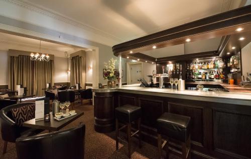 林德赫斯特森林酒店的餐厅内的酒吧配有桌椅