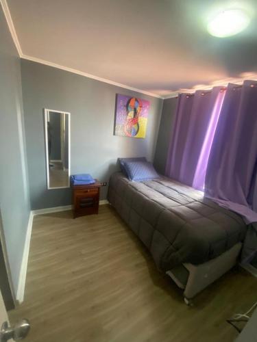 La Chimbacasa的一间卧室配有一张紫色窗帘的床