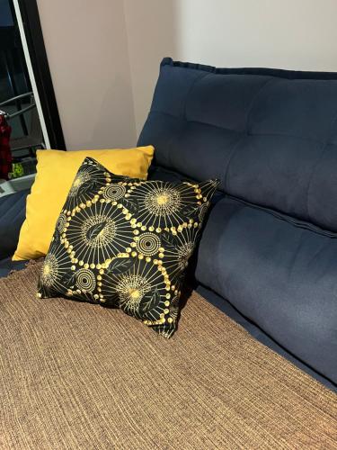 伊列乌斯Cantinho baiano Ilhéus Ba的沙发上的一个黑色和金色枕头