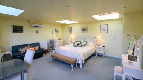 科尔切斯特雉鸡乡村民宿的一间大卧室,配有一张床和一张沙发