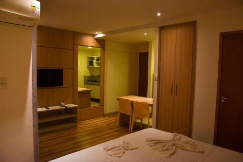 费拉迪圣安娜Studio Moderno bem localizado的酒店客房配有一张床铺、一张桌子和一张书桌。