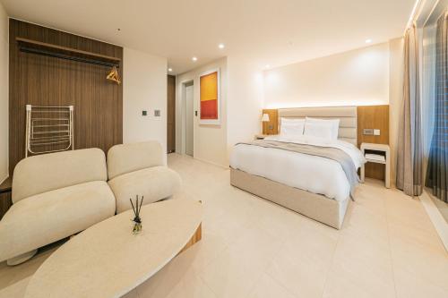 西归浦市Haeilri Pool&SPA Hotel的酒店客房,配有床和沙发