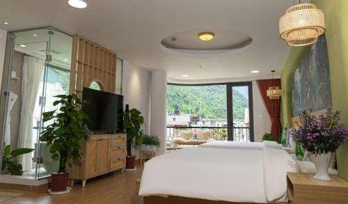 萨帕Tropical Paradise Sapa Hotel & Coffee的卧室配有白色的床和电视。