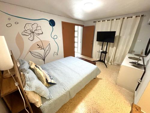 圣胡安Bee Inn Puerto Rico Charming Urban Apartment in San Juan的卧室配有一张挂着花壁画的床。