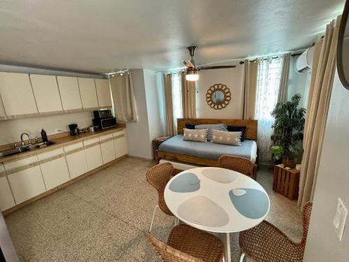 圣胡安Bee Inn Puerto Rico Charming Urban Apartment in San Juan的厨房以及带桌子和床的客厅。