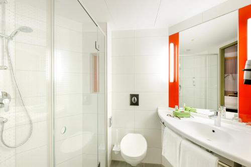 慕尼黑宜必思慕尼黑阿穆尔公园酒店的浴室配有卫生间、盥洗盆和淋浴。