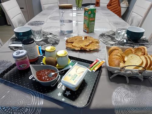 Saint-Méen-le-GrandCœur de ville, chambre confortable à louer en Bretagne的一张桌子上放着一个食品和面包盘