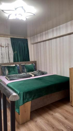 第比利斯Marie apartament的一间卧室配有一张带绿毯的床