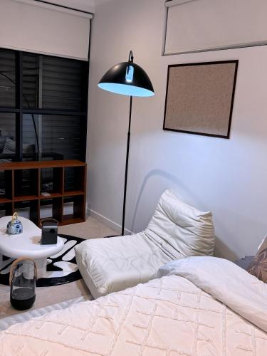 悉尼Private room with Balcony的一间卧室配有一张床、一张桌子和一盏灯