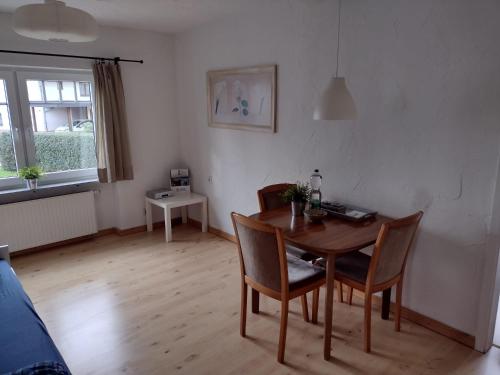 NauortFerienwohnung mit Herz的客厅配有木桌和椅子