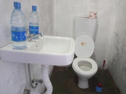  Kibale Forest National ParkKibale Tented Camp的浴室设有卫生间和带2瓶水的水槽。