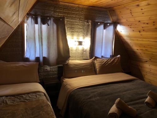 泰斯Bujtina Pllumi Theth的一间卧室设有两张床和两个窗户。