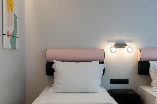 雅典PAREA Athens的一张带白色枕头和灯的床