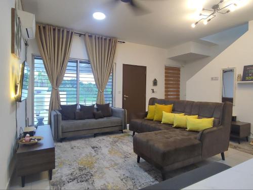 万津Homestay Banting Selangor的客厅配有两张沙发和黄色枕头