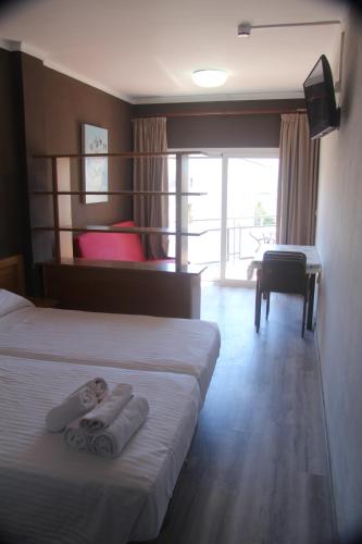 罗萨斯Aparthotel Els Molins的酒店客房,配有两张带毛巾的床