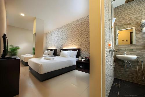 吉隆坡Izumi Hotel Bukit Bintang Kuala Lumpur的一间卧室配有床和水槽,还有一间浴室