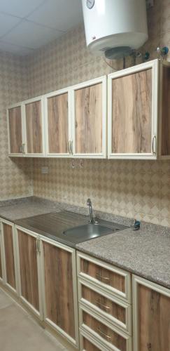 艾恩HOUSE IN AL AIN - 4的一个带水槽和木橱柜的厨房