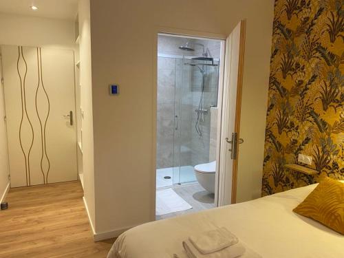 布格奈斯La Maison Blanche的一间卧室配有一张床,浴室设有淋浴。