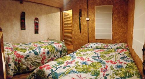 莱瓦镇Casa de leña, cabaña rural的一间卧室配有两张床和镜子
