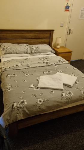 格雷夫森德萨姆洛克盖斯特酒店的一张带毯子的床,上面有毛巾