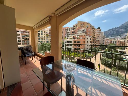 蒙特卡罗Monaco Port de Fontvieille elegant terraced apartment with Garden View and Pool Access的阳台配有玻璃桌和椅子