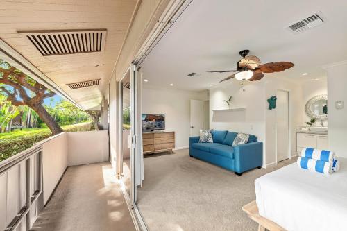 拉海纳Maui Eldorado - B206的一间卧室配有一张床和一张蓝色的沙发