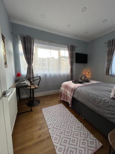 霍利Dana’s bungalow的一间卧室配有一张床、一张书桌和一个窗户。