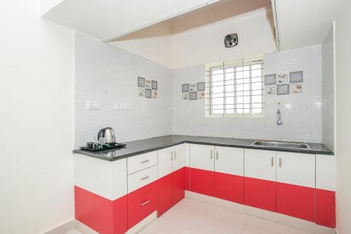 班加罗尔Manyata Royal Mac的厨房配有红色和白色的橱柜和水槽