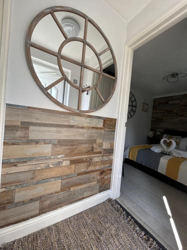 霍利Dana guest suite的卧室配有再生木墙和圆形镜子