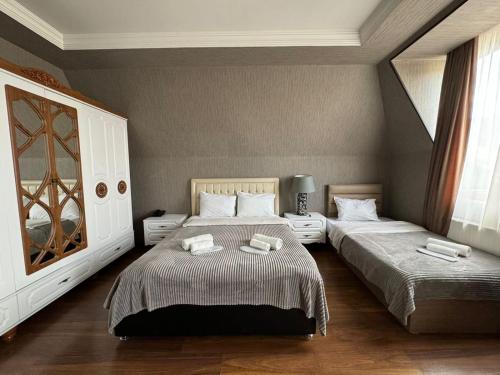 第比利斯里奇酒店的一间卧室配有两张带毛巾的床