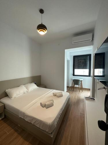 普里什蒂纳Pristina Select Apartments的一间卧室配有一张床,上面有两条毛巾