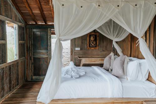 贾蒂卢维D'Ume Bendoel Homestay的一间卧室配有一张带天蓬的白色床