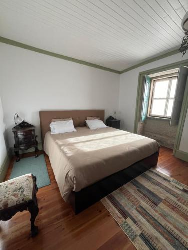 FarminhãoCasa do Compasso的一间卧室设有一张大床和一个窗户。