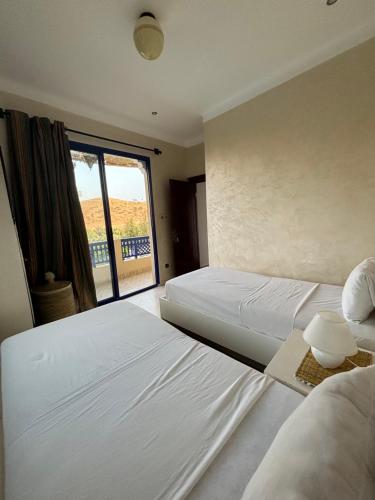 OuaouizeltMakhfamane Land的配有窗户的酒店客房内的两张床