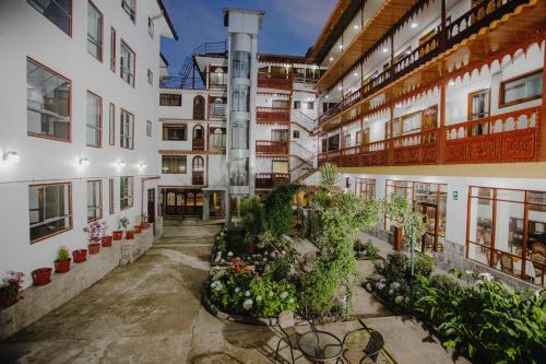库斯科Quechua Hotel Cusco的庭院里植物林立的公寓楼