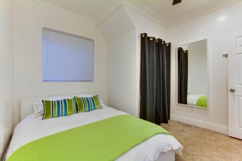 圣地亚哥199-surf Stars Combo的卧室配有绿色和白色的床和镜子