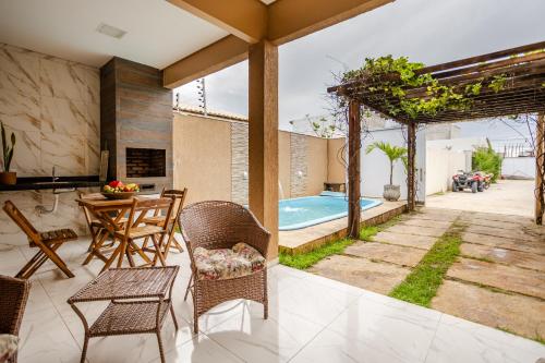 普雷亚Casa no PREÁ COM PISCINA !的一个带桌椅的庭院和一个游泳池