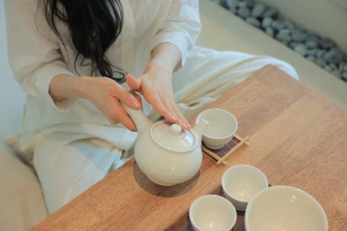 始兴市Aank Hotel Incheon Wolgot的女人把液体倒进茶壶里