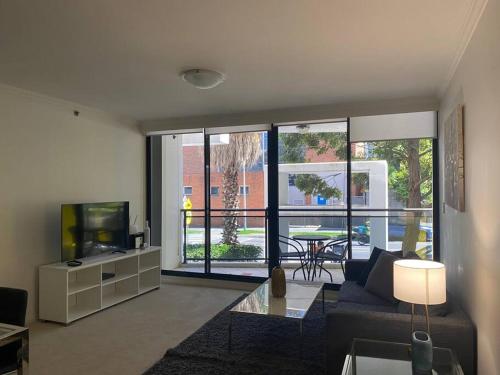 悉尼Ultra Convenient St Leonards Apartment HER09008的带沙发和电视的客厅