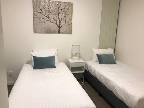 悉尼Stylish two bedroom in St Leonards ALB91105的两张睡床彼此相邻,位于一个房间里