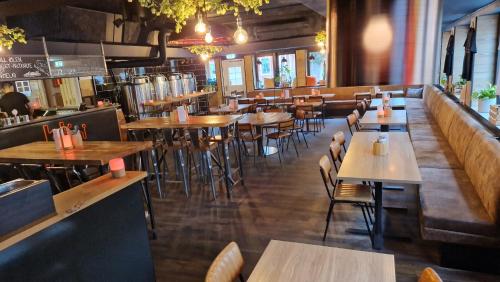 卡尔斯克鲁纳The Brewery Hotel的一间带木桌椅的餐厅和一间酒吧