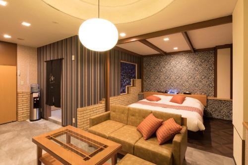 Yatomi Hotel Nuqu Natural Hot Spring的一间卧室配有一张床和一张沙发