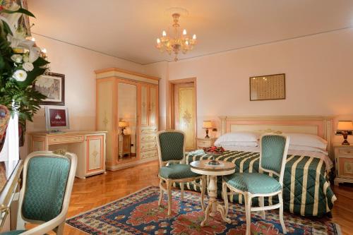 威尼斯阿尔伯高卡瓦乐图奥尔瑟罗公爵酒店的卧室配有一张床和一张桌子及椅子