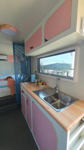 HaBonimCountryside, beach view glamping caravan的厨房设有水槽和窗户。