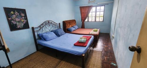 古晋Tatai Kumang Homestay的一间小卧室,配有一张床和一把椅子