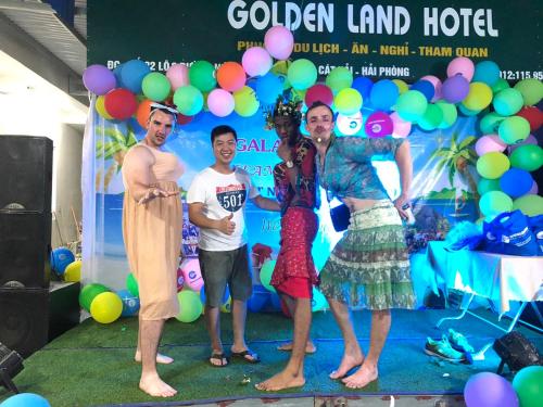 吉婆岛GOLDEN LAND HOTEL的一群人站在一个背景前,拿着气球