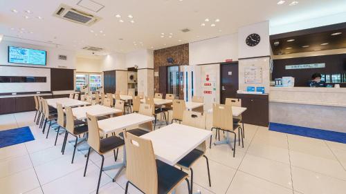 大阪Toyoko Inn Shin-Osaka-eki Higashi-guchi的一间带桌椅和柜台的餐厅