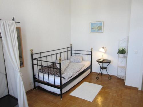 纳沙泰尔Guest house - Maison d'hôtes "Relais des Saars"的一间小卧室,配有一张床和一张桌子