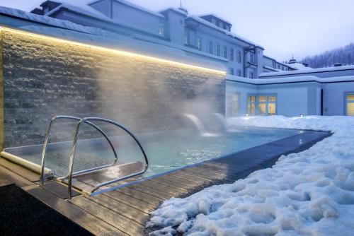 圣莫里茨Grand Hotel des Bains Kempinski的雪覆盖的房子里的热水浴缸