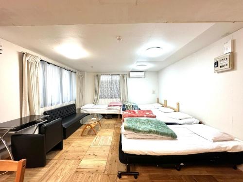草津Shibasaki House 1F - Vacation STAY 13848的客房设有三张床和一张书桌